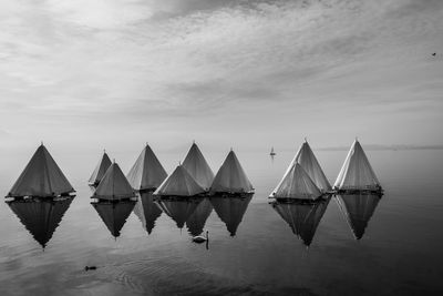 Tents with reflection in lake thun against sky