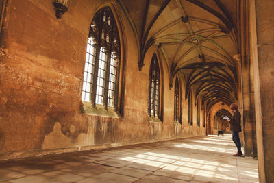 Side view of woman standing in corridor