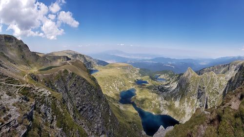 Panoramic view of landscape and mountains against blue sky