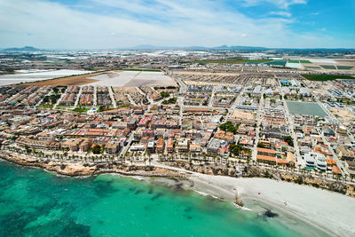 High angle view of townscape by sea against sky