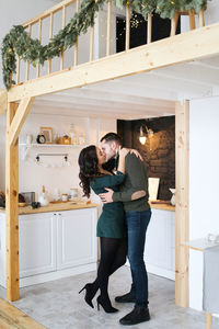 A happy couple in love are preparing for the christmas holiday in the decorated kitchen of the house