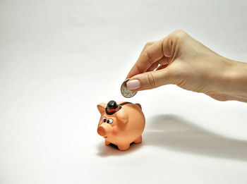 Close-up of hand holding toy against white background