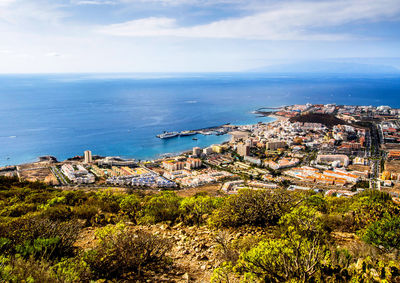 High angle view of town by sea against sky