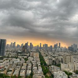Aerial view of buildings in city against sky