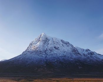 Scenic view of snowcapped mountain against blue sky