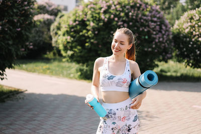 Happy fun healthy athletic girl in sportswear training and exercising in the park in nature outdoors