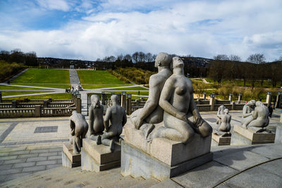 Statues on staircase against sky