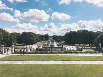 People at park against cloudy sky