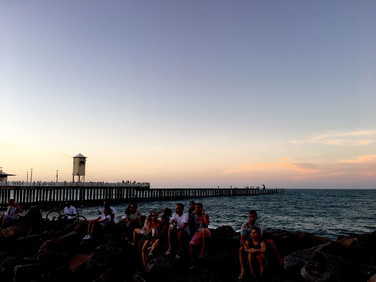 PEOPLE AT BEACH AGAINST CLEAR SKY