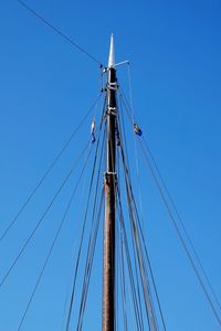 Low angle view of sailboat against clear blue sky