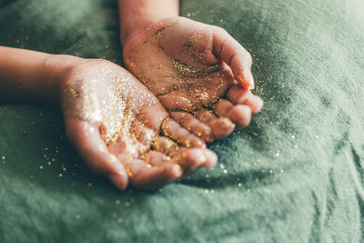 Close-up of person hand covered in glitter