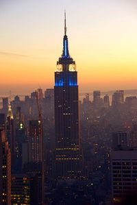 Skyscrapers in city at sunset