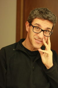 Close-up portrait of smiling man wearing eyeglasses at home