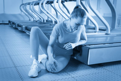 Full length of young woman exercising in gym