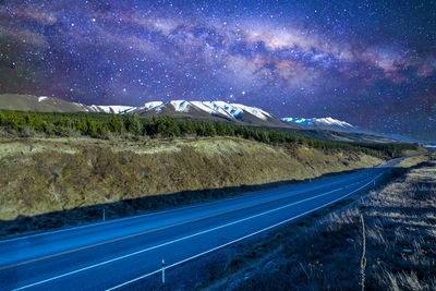 Road by mountains against sky