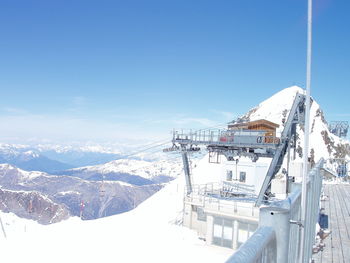 Ski lift over snowcapped mountain against sky