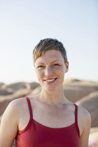 Portrait of a smiling mid adult woman against clear sky