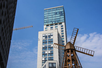 Low angle view of building and traditional windmill against sky