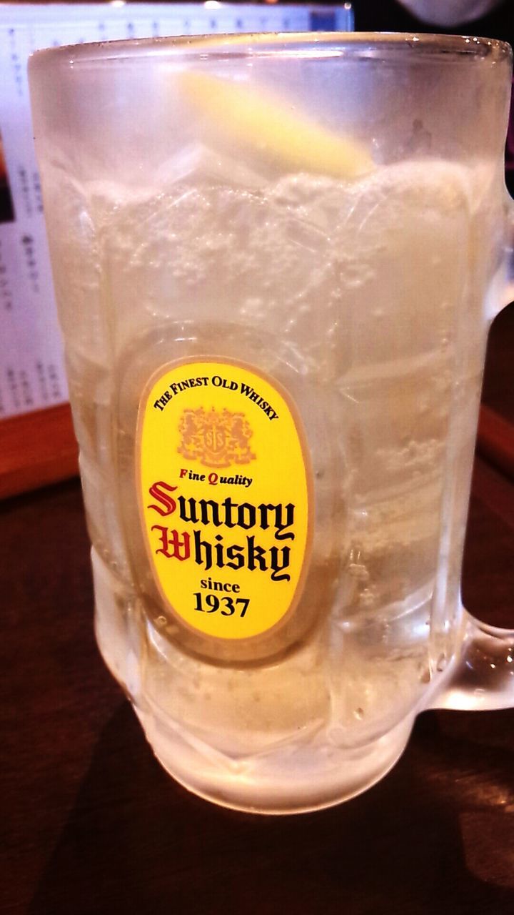 text, drink, food and drink, western script, refreshment, indoors, communication, freshness, close-up, drinking glass, table, still life, glass - material, yellow, transparent, no people, alcohol, glass, frothy drink, focus on foreground