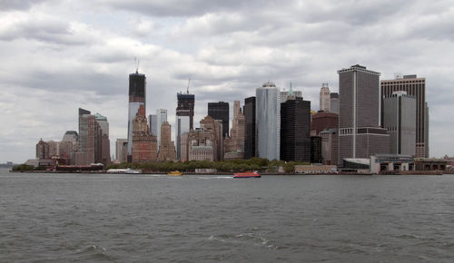 Sea by buildings against sky in city