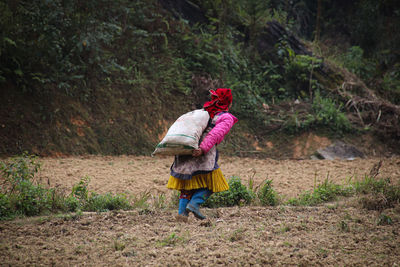 Rear view of woman standing on field