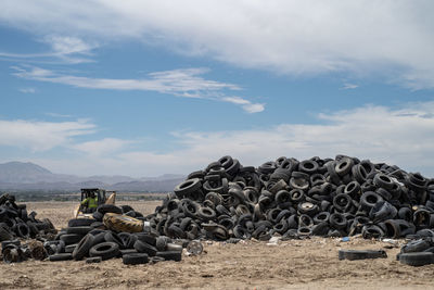 Stack of stones on field against sky