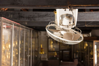 Low angle view of electric fan mounted on roof beam