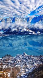 Aerial view on zell am see city, lake, reflections among sunny winter alp mountains in austria