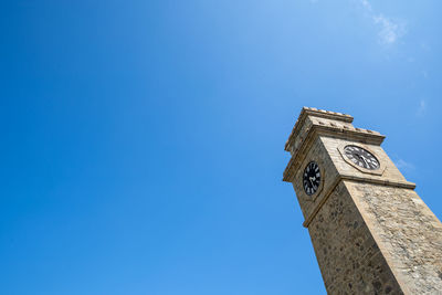 Low angle view of clock tower against blue sky