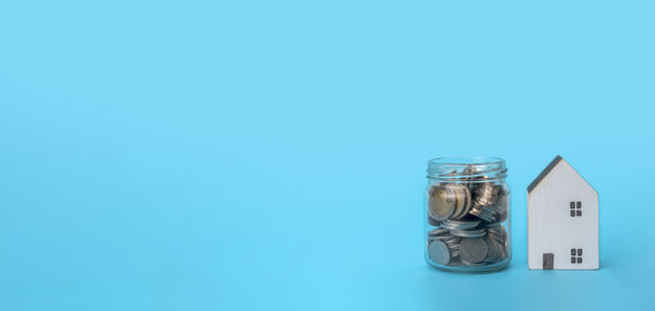 Close-up of glass jar on table against blue background