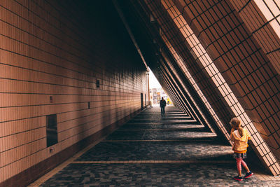Rear view of people walking on footpath