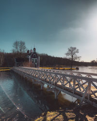 Bridge over river against clear blue sky