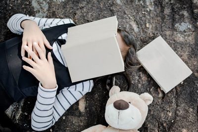 Directly above shot of girl with book on face