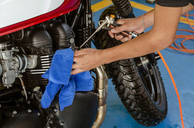 Cropped hands of man repairing motorcycle