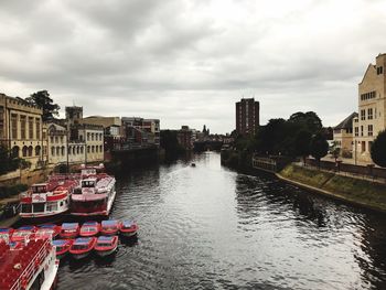 River amidst buildings in city against sky