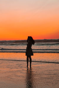 Full length of silhouette man standing on beach during sunset