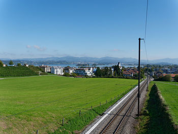 Railroad track amidst field against sky