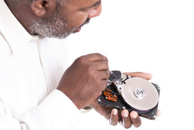 Midsection of man holding camera against white background