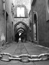 Rear view of woman walking on cobblestone