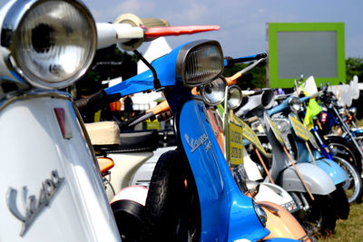 Close-up of motor scooter parked against blue sky