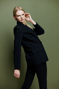 Young woman standing against yellow background