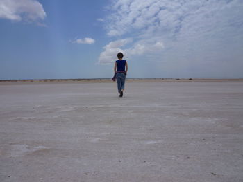 Rear view of woman walking in desert