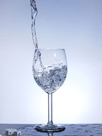 Close-up of wine glass against water