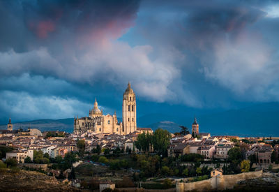 Buildings in town against cloudy sky