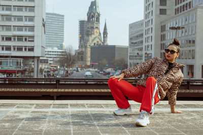 Portrait of woman crouching in city