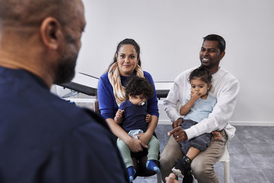 Male doctor talking to family with children