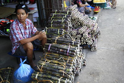 High angle view of mid adult man selling sugarcane at market stall