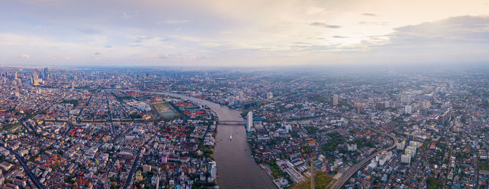 High angle view of crowd by buildings against sky during sunset