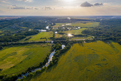 Top view of green fields. beautiful forest, blue sky, clouds. river flows.