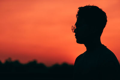 Portrait of silhouette man against orange sky